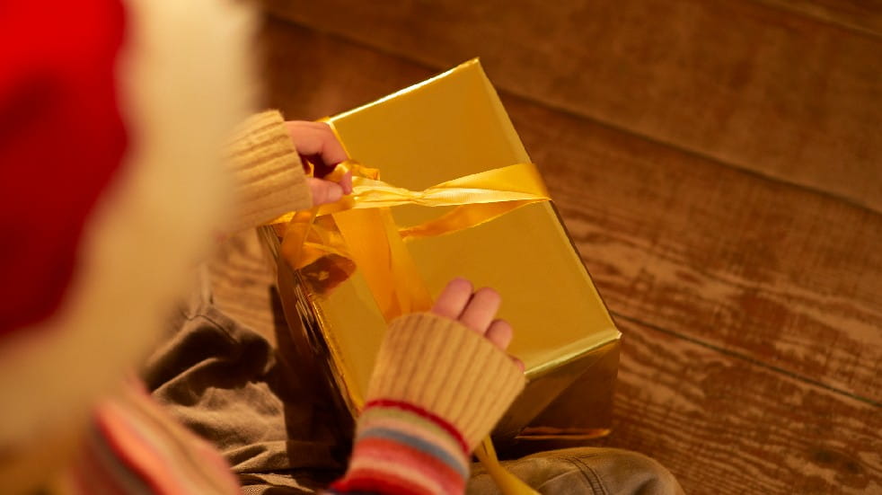 person unwrapping christmas present